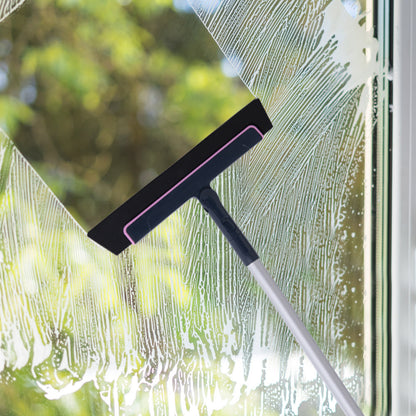 Floor squeegee wiping water off a glass window
