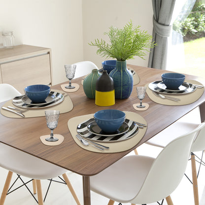 Beige curved placemats on a round wooden dining table